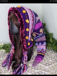 a wig with a hat on top of it sitting next to a white brick wall