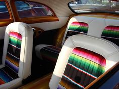 the inside of a car with colorful seats and dash strips on it's sides