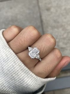 a person's hand with a diamond ring on it