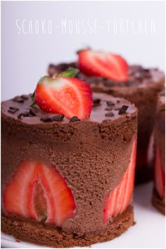 two cakes with chocolate frosting and strawberries on top