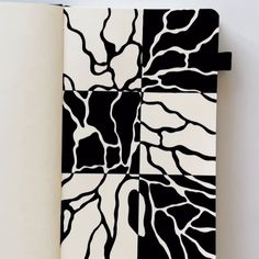 an open notebook with black and white designs on it