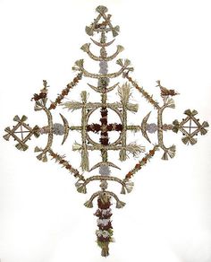 an ornate cross made out of flowers and leaves on a white background with no people around it