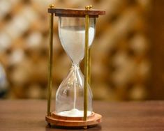 an hourglass sitting on top of a wooden table