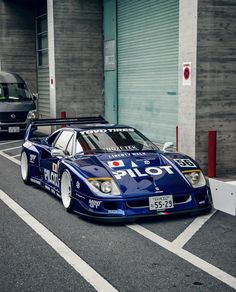 a blue race car parked in front of a building