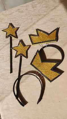 three yellow and black glittered stars on top of a white table cloth next to each other