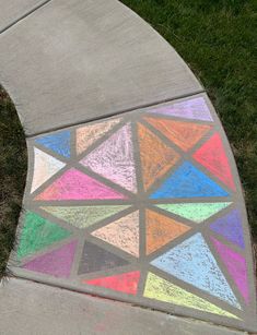 the sidewalk is painted with colored chalks and has a circular design on it's side