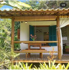 a wooden table sitting on top of a wooden deck next to a lush green forest