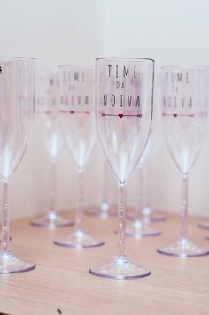 five wine glasses sitting on top of a wooden table next to each other with words written on them