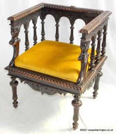 an old wooden chair with a yellow cushion on it's armrest and legs