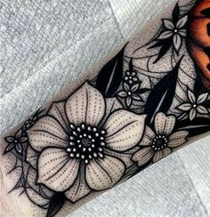 a black and white flower tattoo on the arm