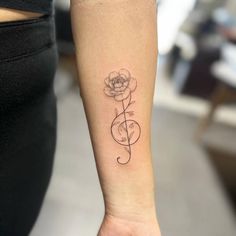 a woman's arm with a flower tattoo on the left side of her wrist