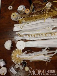 many different types of ribbons and thread on a wooden table with other items around them