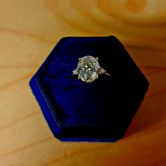 an engagement ring sits in a velvet box