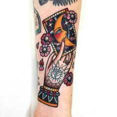 a woman's arm with tattoos on it and an image of a hand holding a clock