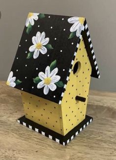 a bird house with flowers painted on it