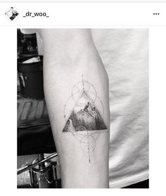 a man's arm with a mountain tattoo on it