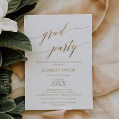 a white and gold wedding card with greenery