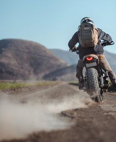 a person riding a motorcycle on a dirt road