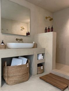 a bathroom with a sink, mirror and towel rack on the wall next to it