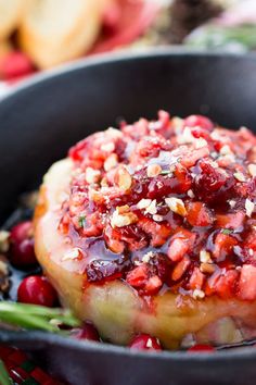 a pan filled with meat covered in cranberry sauce and garnished with nuts