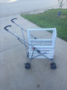 a small cart that is sitting on the sidewalk with two handles and wheels attached to it