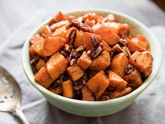 a bowl filled with carrots and nuts on top of a table