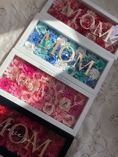 three boxes filled with different colored flowers and the word mom spelled in cursive writing