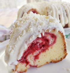 a close up of a piece of cake on a plate with icing and strawberries