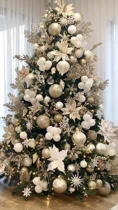 a decorated christmas tree with silver and white ornaments