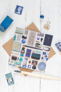 an assortment of stationery items laid out on top of a wooden table next to a pencil