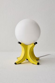 an egg sitting on top of a yellow stand with a white light in the middle