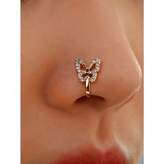 a close up view of a nose with a butterfly shaped nose ring on it's side