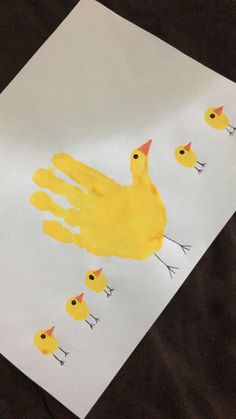 a child's handprint with yellow ducks on it, and an adult duck in the background