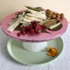 there is a plate with fruits and vegetables on the cake stand, ready to be eaten