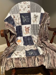 a chair with a blanket on top of it and a teddy bear sitting in the back