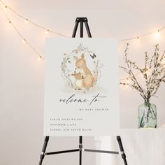 an easel with a sign that says welcome to the baby in front of some lights