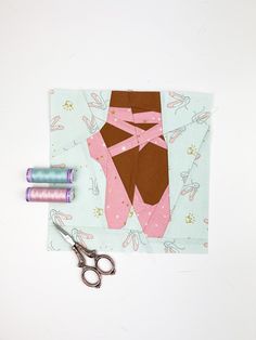 sewing supplies including scissors, thread and fabric on top of a piece of paper with an image of a woman's skirt