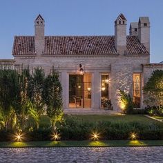 a house that is lit up at night with lights on the front and side windows