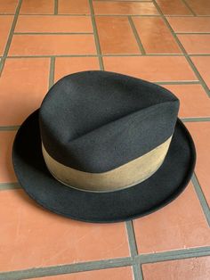 "For your consideration Vintage 60s era CHAMP KASMIR Finish black fedora hat Gold wide grosgrain ribbon 2\" wide Leather sweatband Shows some light dust from storage & minor wear .. couple minor indentions (top crown and large one on side crown) .. interior liner shows age with light dust and soiling , nicely broken in and very handsome! 100% Fur felt Manufacturing tag on inside sweatband Tag marked size 7 1/8 or 57 cm or Medium Shown on vintage size medium mannequin 2.\" brim 4\" crown 6 2/ Retro Fitted Fedora With Curved Brim, Retro Fedora With Curved Brim, Fitted Retro Fedora With Curved Brim, Retro Fitted Brimmed Fedora, Retro Fitted Fedora With Brim, Vintage Fitted Fedora With Flat Brim, Vintage Brown Fedora With High Crown, Vintage Fitted Fedora With Brim, Vintage High Crown Brown Fedora