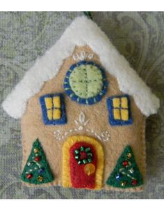 a felt house ornament hanging on a wall