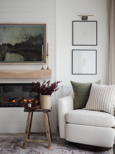 a living room filled with furniture and a fire place in front of a painting on the wall