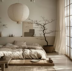 a bed with white sheets and pillows next to a tree in front of a window