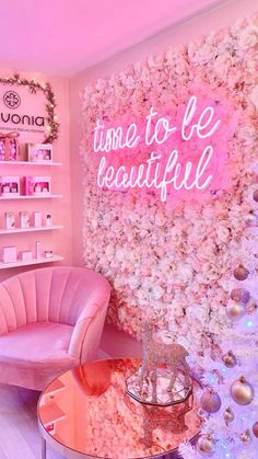 a room with pink furniture and flowers on the wall that says time to be beautiful