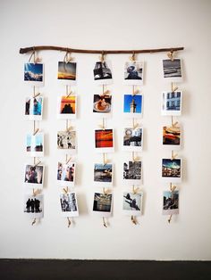 a bunch of pictures hanging on a wall with clothes pins attached to the pegs