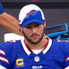 a close up of a football player wearing a blue and white hat with the bills logo on it