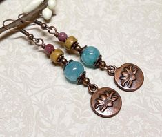 Everyday boho style dangle earrings created using blue Quartzite stone beads, Picasso Jasper heishi gemstone beads, small round Mookaite Jasper beads, copper accents, and antique copper lotus flower charms. Total length of earrings, including the ear wire, is approximately 2-1/2".  The bronze lotus flower charms measure approximately 1/2" x 1/2". Thank you for shopping with The Lucie Collection! Bohemian Gemstone Beads Earrings, Bohemian Drop Earrings With Gemstone Beads, Bohemian Gemstone Beaded Earrings As Gift, Bohemian Teardrop Gemstone Bead Earrings, Blue Quartzite, Earthy Jewelry, Mookaite Jasper, Copper Accents, Picasso Jasper