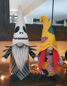 two halloween gnomes sitting on top of a counter next to each other, one with long white hair and the other with red hair