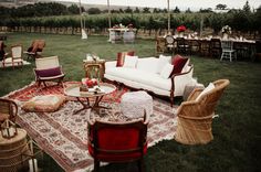 a living room filled with lots of furniture on top of a field covered in grass