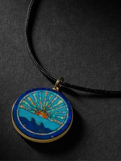 Handcrafted to be a ""talisman of energy""; Jacquie Aiche's gold pendant necklace is strung with black cord and features a shining seascape. The intricate design is inlaid with pieces of turquoise and lapis. Luxury Turquoise Engraved Jewelry, Luxury Engraved Turquoise Jewelry, Luxury Blue Medallion Jewelry, Blue Coin Pendant Jewelry, Blue Engraved Amulet Jewelry, Blue Engraved Amulet Style Jewelry, Blue Jewelry With Detachable Round Pendant, Blue Jewelry With Detachable Pendant, Unique Blue Medallion Jewelry