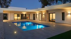 a modern house with a swimming pool at night